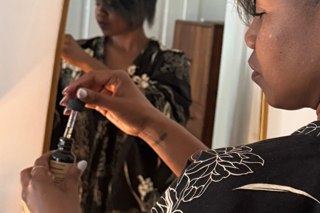 Person wearing a black kimono with cream floral patterns, standing in front of a mirror.
